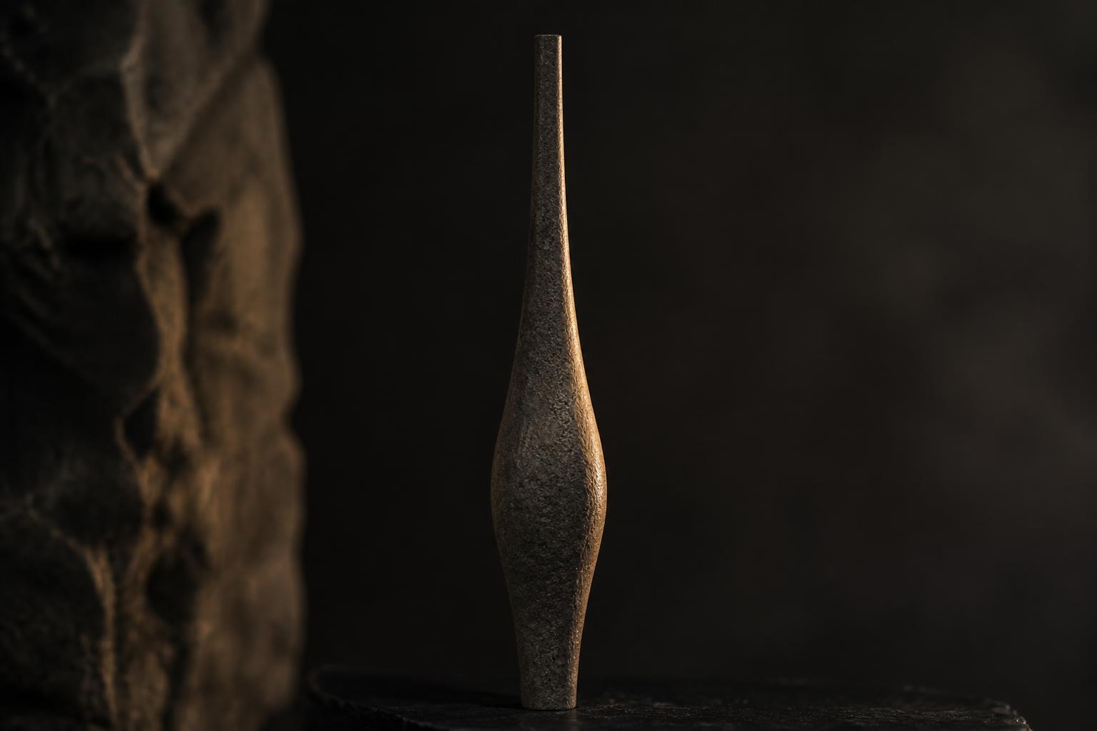 Abstract still life: a slender sculpted stone column with a subtle swell tapering to a fine line, standing in for calf contour treatment.
