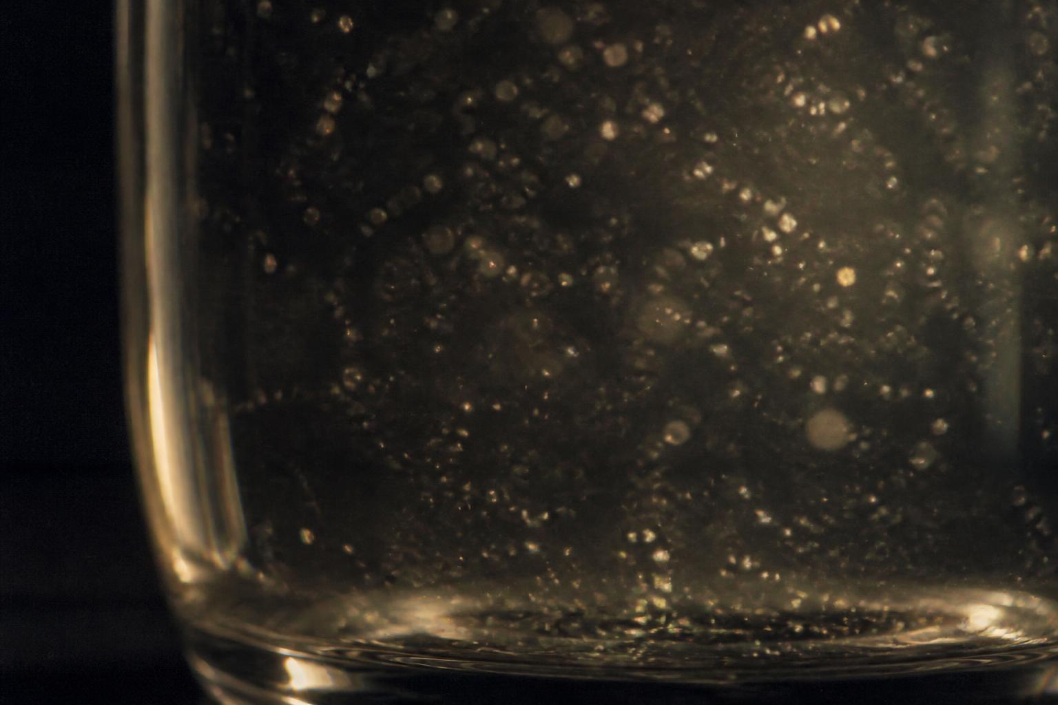 Abstract macro still life: fine particles suspended in a clear gel, standing in for a polylactic acid microparticle injectable.