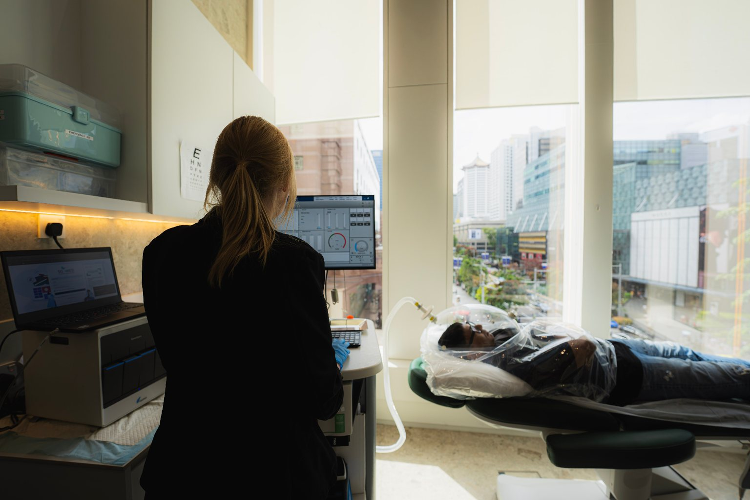 Clinician monitoring an indirect calorimetry test while a patient rests under the measurement canopy at the Orchard clinic.