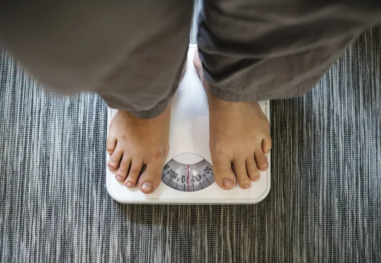 Person on weighing scale during a weight management programme