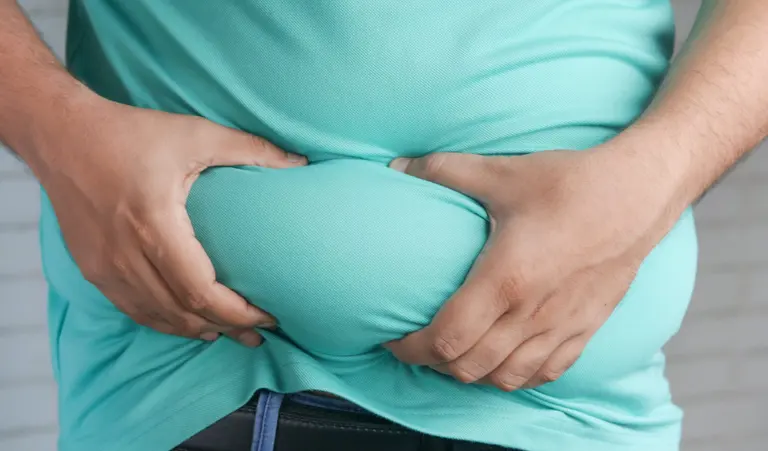 Man measuring his waist during an obesity and metabolic health assessment in Singapore